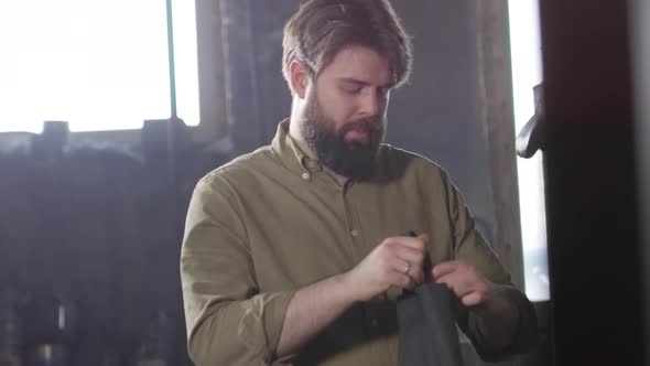 Worker Putting on Apron in Workshop alt