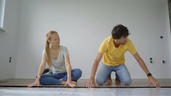 A Family of Woman and Man Install Laminate on the Floor in Their Apartment alt
