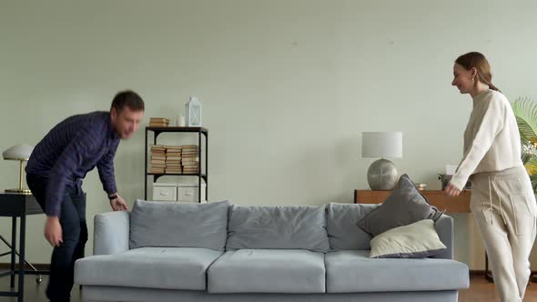 Happy Young Couple Moving New Couch Into Living Room Fall It To Rest alt