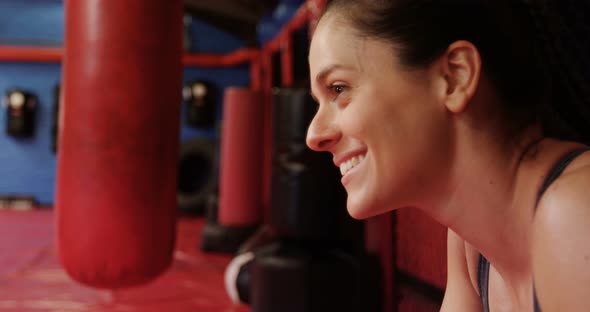 Smiling female boxer standing in fitness studio alt