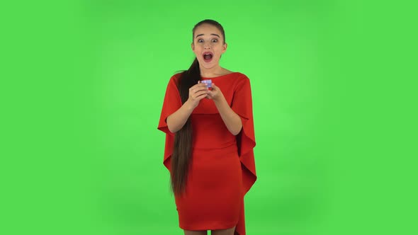 Pretty Young Woman Is Opening a Small Box with a Surprise and Is Very Disappointed with What She Saw alt