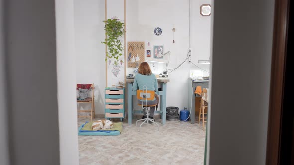 Back View Of A Girl Jeweler Working Inside The Studio alt