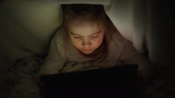 Girl Watching Film on Tablet at Night alt