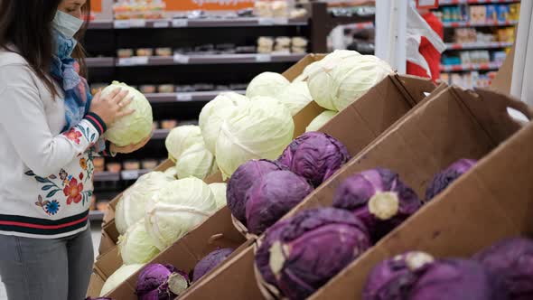 Young Woman in Protective Mask Buying Cabbage alt