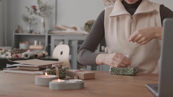 Craftsperson Decorating Christmas Gift Boxes alt