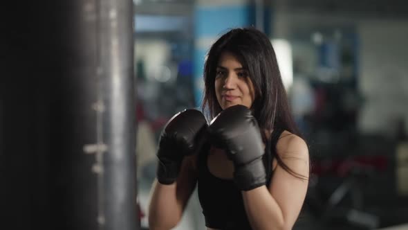 Slim Beautiful Young Woman Boxing Punching Bag in Gym Working Out alt