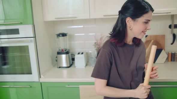 Young Woman Make Fun Singing and Dancing While Baking at Home Kitchen