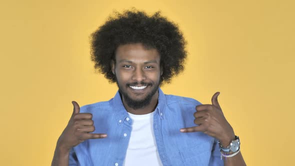 AfroAmerican Man Gesturing Thumbs Up on Yellow Background alt