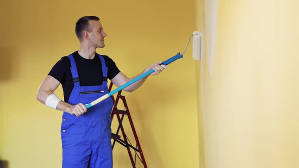 Man painting wall during home decoration with roller brush alt