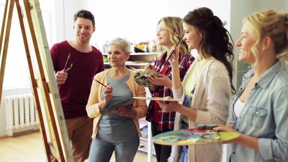 Group of Artists Discussing Painting at Art School alt