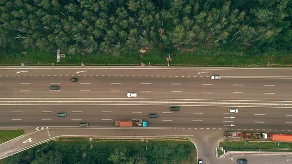 Traffic of Cars and Trucks on the Sixlane Freeway in Summer Day  Top View Shot alt