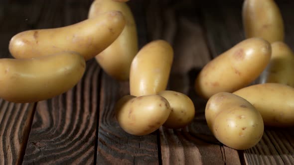Super Slow Motion Shot of Potatoes Rolling on Old Wooden Table at 1000Fps alt