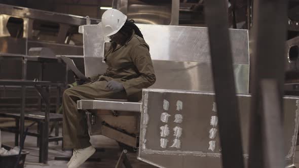 Woman Sitting on Metal Framework Working alt