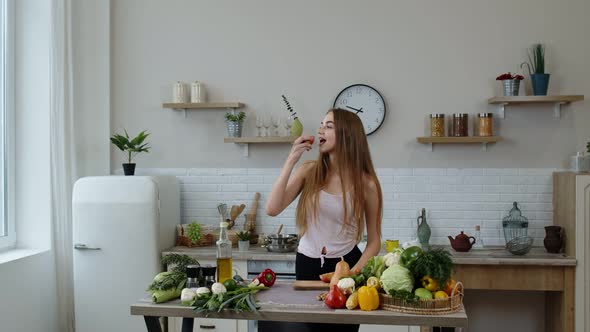 Pretty Young Girl Coming To the Table with Juicy Apple. Cutting with Knife and Eating Fresh Fruit alt