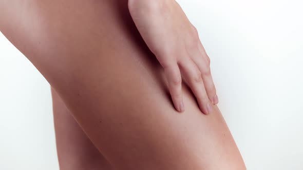 Woman Applying Moisturizer Cream or Body Lotion on Her Legs