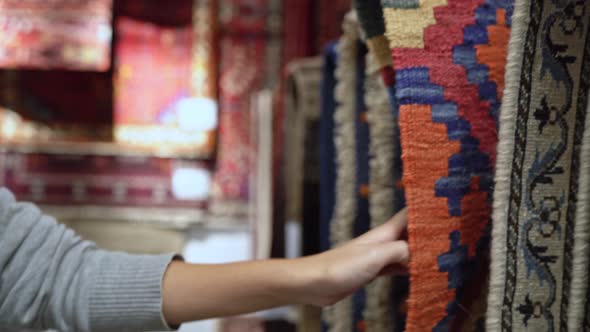 Young Asian woman choosing interesting fabric happy shopping in clothing store. alt