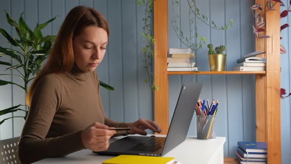 Woman Sit at Desk Use Laptop Holding Plastic Card Having Problems