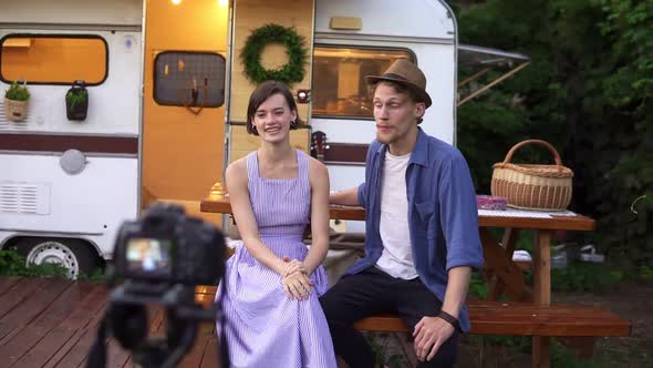 Cheerful Young Bloggers Couple Recording Video About Their New Life or Vacation in Wheels House alt