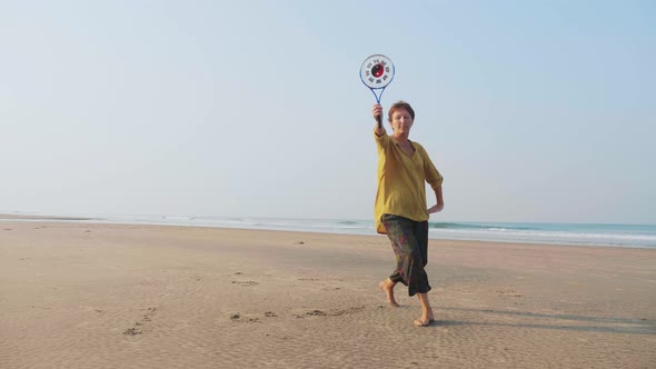 Senior Woman Practicing Tai Chi Balloon Ball on the Beach alt