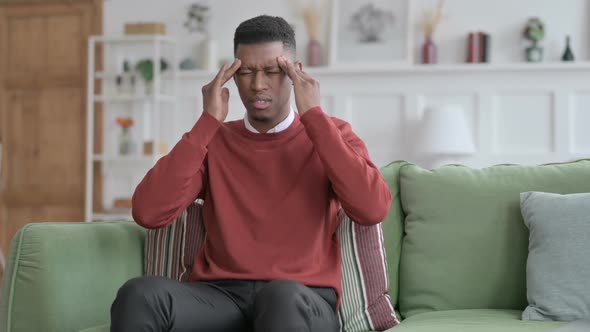 African Businessman having Headache on Sofa alt