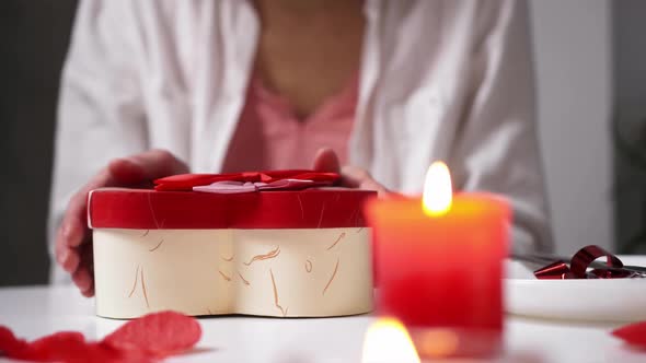 Happy Young Girl Opens Heart Gift Box. A Gift To Your Girlfriend During Romantic Candlelit Dinner alt