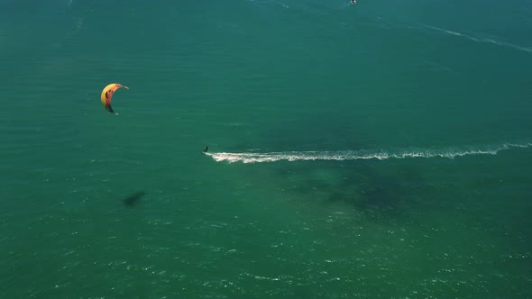 scenic high altitude drone pickup wide shot of kite surfing on Langebaan beach, South Africa with pe alt