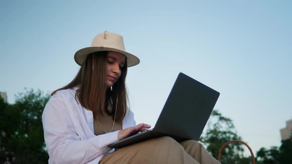 A Young Girl Works at Her Laptop