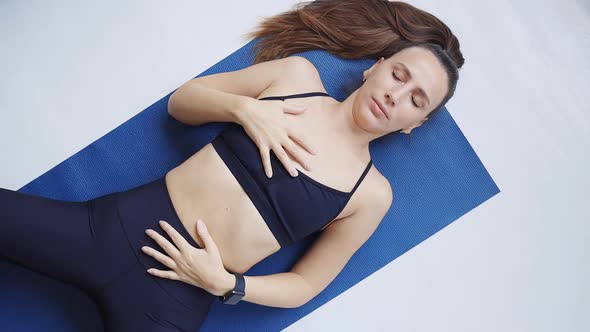 Young Fitness Woman Relaxing Lying Down in Shavasana Yoga Pose