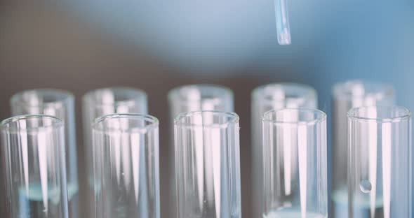 Extreme Close Up of Pipette Dropping Water Into Sample Tube at Laboratory alt