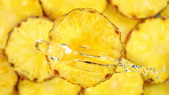 Super Slow Motion Shot of Splashing Water on Rotating Pineapple Slice at 1000Fps alt