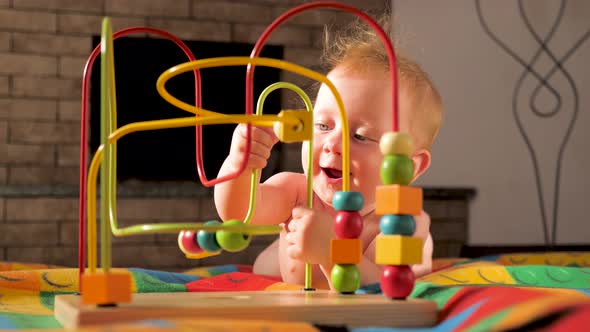 The baby develops fine motor skills. Montessori toy. Toddler playing with a Montessori toy. alt