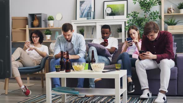Group of Young People Using Smartphones Touching Screen at Home Together alt