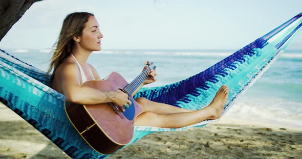 Woman Playing Guitar on the Beach alt