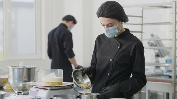 Slim Young Confectioner Pouring Nuts in Bowl in Slow Motion As Blurred Man Cooking Pastry at alt