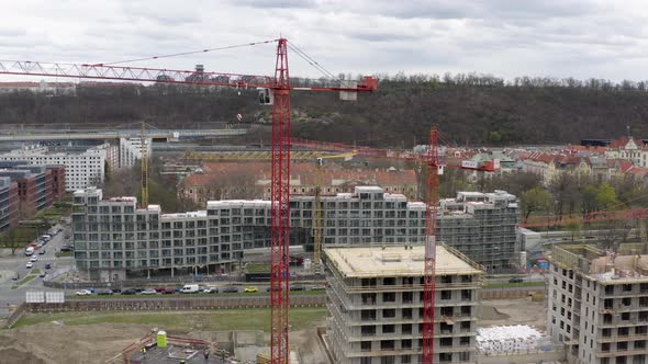 Tall red tower cranes at construction site in Prague city center. alt