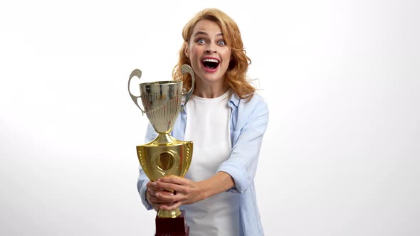 Amazed Happy Woman Celebrate Victory and Kiss Golden Cup Winner