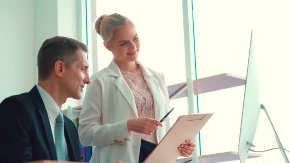 Two Business People Talk Project Strategy at Office alt