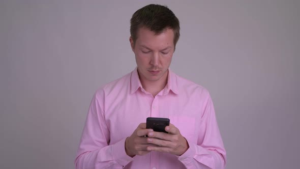 Young Happy Businessman Using Phone and Giving Thumbs Up alt