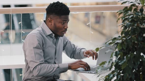 Shocked Young Businessman Working on Laptop Feeling Frustrated Stressed By Problem Despair alt