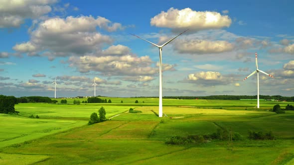 Aerial view of wind turbines with blue sky on green field , Poland alt