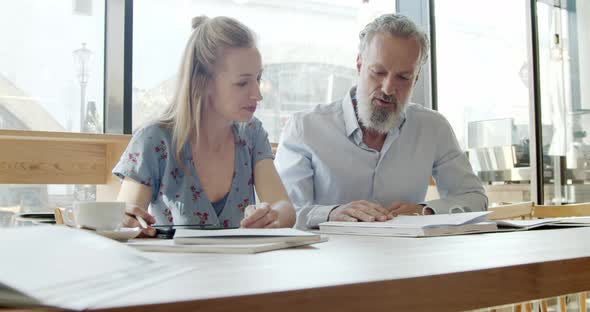 Two business partners having a meeting at a cafe alt