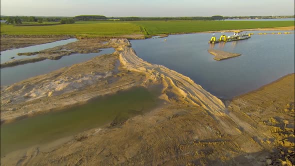 Aerial in approaching a dredger in a typical Dutch agricultural water land alt