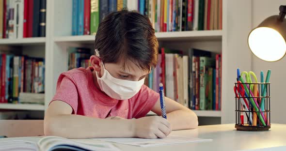 Student Wearing Surgical Mask Working on School Assignments