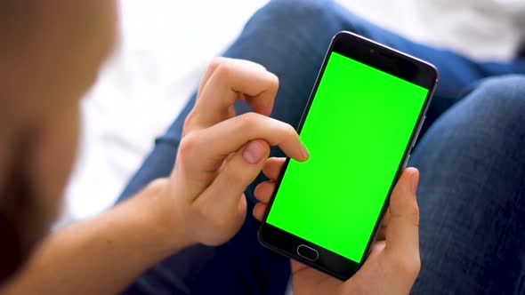 Black Smartphone with Green Screen for Chroma Key Swipe Up Compositing the Hands of a Man