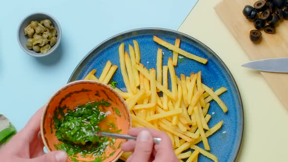 Vertical Tabletop Video Chef Adds Green Sauce to the Fried Potato Dish