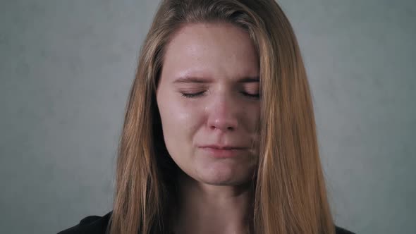 Young Woman Crying Looking at the Camera. Tears Comes Out of an Eyes