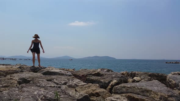 Young woman walking on rocks near the sea