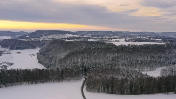 Idyllic winter day after snow was falling. Slow drone flight over groups of trees with the view over alt