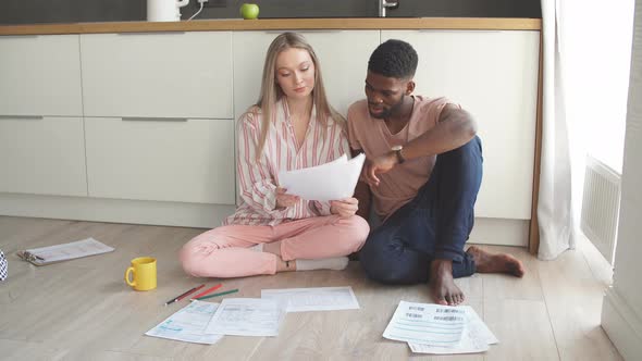 Interracial Family of Young Attractive Architects in Home Wear, Working on a Project Together. alt