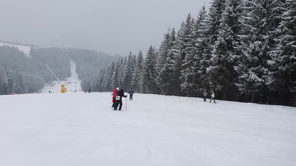 People skiing on the snowy slope of Bukovel ski resort in the Ukrainian Carpathian mountains.